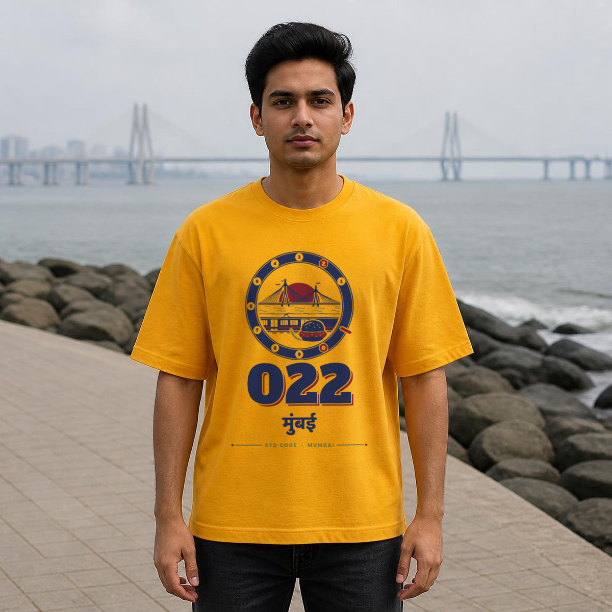 022 Mumbai STD code oversized cotton T-shirt in golden yellow, men's front view at Bandra Bandstand, Bonzo Peter's